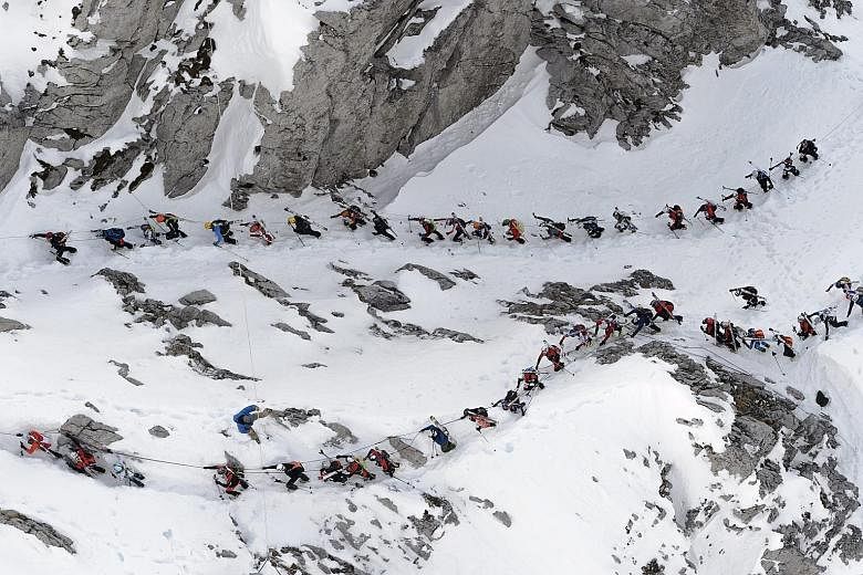 A group of skiers climbing the Col du Pacheu during the 69th edition of the Trophees du Muveran, a ski mountaineering race through the Swiss Alps, above Les Plans-sur-Bex, in Switzerland, yesterday. One of the oldest ski mountaineering races in the w