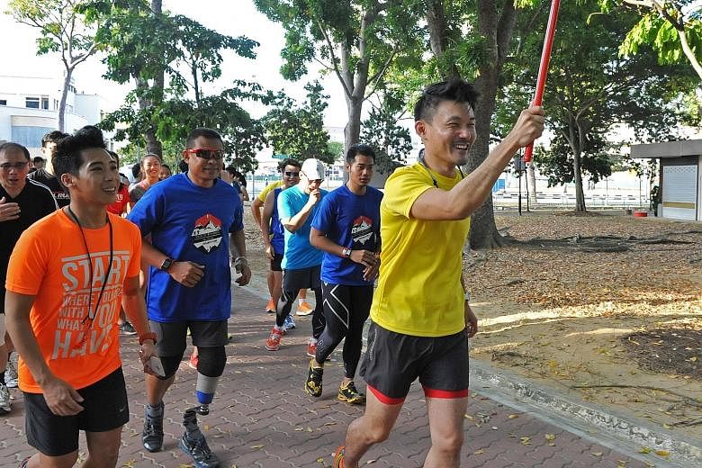 Mr Baey (in yellow) , the Parliamentary Secretary for the Ministry of Culture, Community and Youth, running with a group that includes "Blade Runner" Mr Shariff, Miles for Good project leader Mr Leong (in orange) and other participants in Tampines Ec