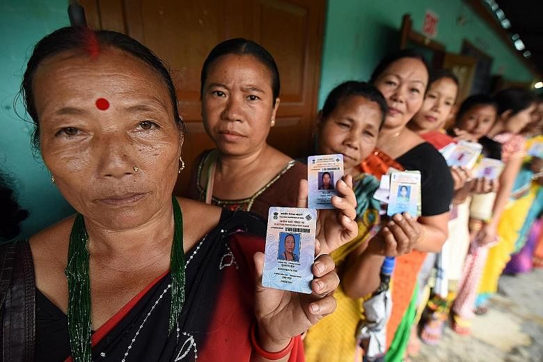 Indian voters, with their identity cards in hand, queueing to cast their ballots in the state assembly elections at a polling station in Diphu in the Karbi Anglong district in Assam state. Nearly 170 million voters are eligible to vote in the stagger