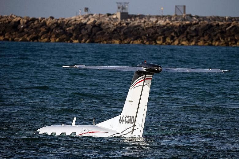 A light Israeli aircraft in the Mediterranean Sea off Tel Aviv's shore after an emergency landing on Sunday. The pilot crash-landed the plane after he failed to make an emergency landing at the Sde Dov Airport. A coast guard patrol rescued him and a 