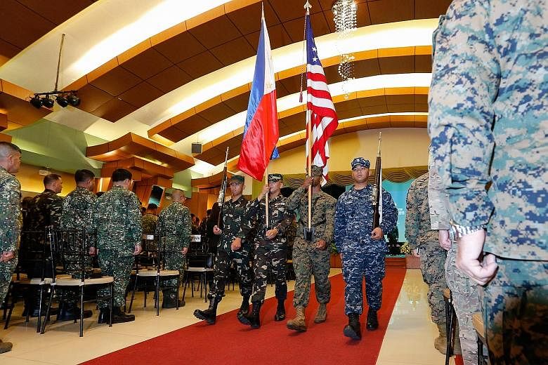 Philippine and US troops carrying their national flags at the Balikatan opening ceremony in Quezon City yesterday. About 80 soldiers from the Australian Defence Force are also joining the drills. Japan and Vietnam have sent observers.