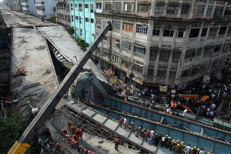 Rescuers and volunteers trying to free people trapped under the collapsed portion of the flyover in Kolkata last Thursday. In many of India's large cities, public works projects are launched by politicians for pre-election boosts and lose their urgen