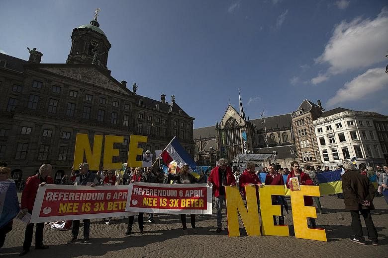 Demonstrators calling for people to vote "no" in the Dutch referendum on an EU free trade deal with Ukraine during a protest in Dam Square, Amsterdam, on Sunday. The banners read: "Referendum April 6. No is 3 times better", while the big letters toge
