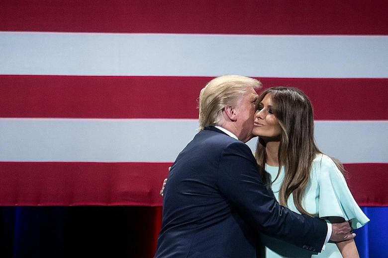 Mr Trump embracing his wife, Melania, on stage in Milwaukee on Monday.