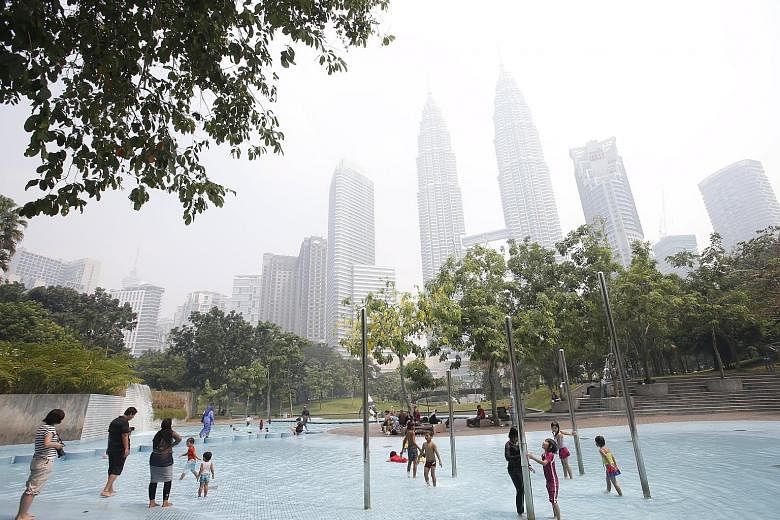 Children at play at a water park near the Petronas Twin Towers in Kuala Lumpur. The ringgit's strength this year is due to oil recovering from US$28 a barrel in January to about US$38 now.