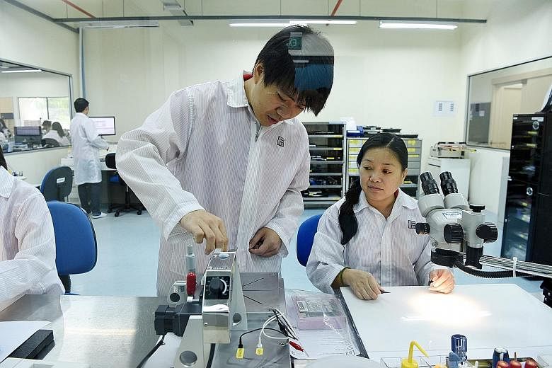 Mr Ng, seen here with test engineer Wong Yok Jung, was sent to Germany for five months' training after joining Feinmetall. On his return, he helped develop a machine to improve a process, boosting productivity by four times and cutting training time 