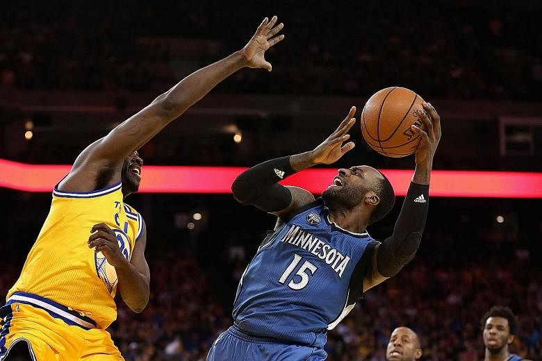 Minnesota's Shabazz Muhammad going up for a shot against Golden State's Draymond Green at the Oracle Arena. The Warriors crashed to their second home defeat in three games, losing the game 117-124.