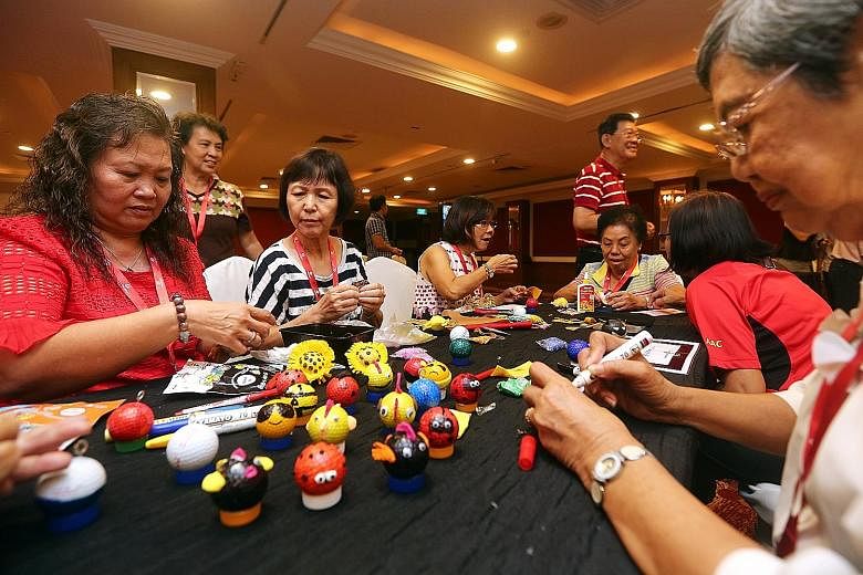 Seniors from Aljunied GRC and Hougang SMC making ornaments out of used golf balls yesterday to raise funds for wellness-related programmes in their areas.