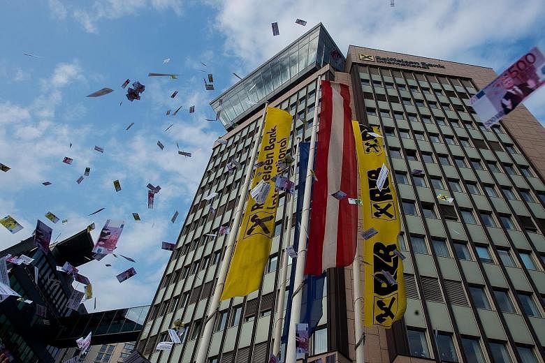Fake money being tossed in the air during a protest against money laundering in front of the headquarters of Raiffeisen Bank International (RBI) in Vienna, Austria, on Wednesday. Leaked documents published on Sunday suggest that 140 politicians and o