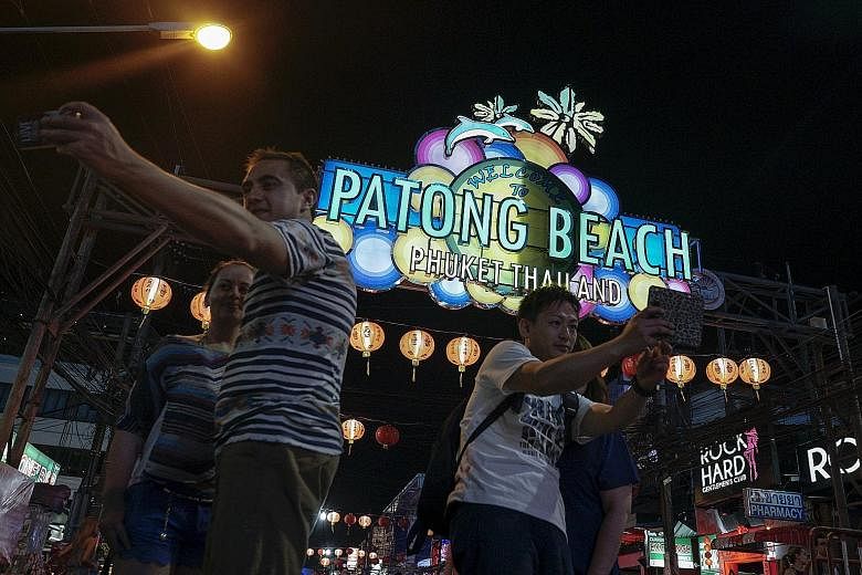 Tourists on a street near Patong beach in Phuket on March 29. Police chief Chakthip Chaijinda said yesterday the warning was real, but called for calm as Thailand gears up for its crowd-pulling Songkran festival next week.