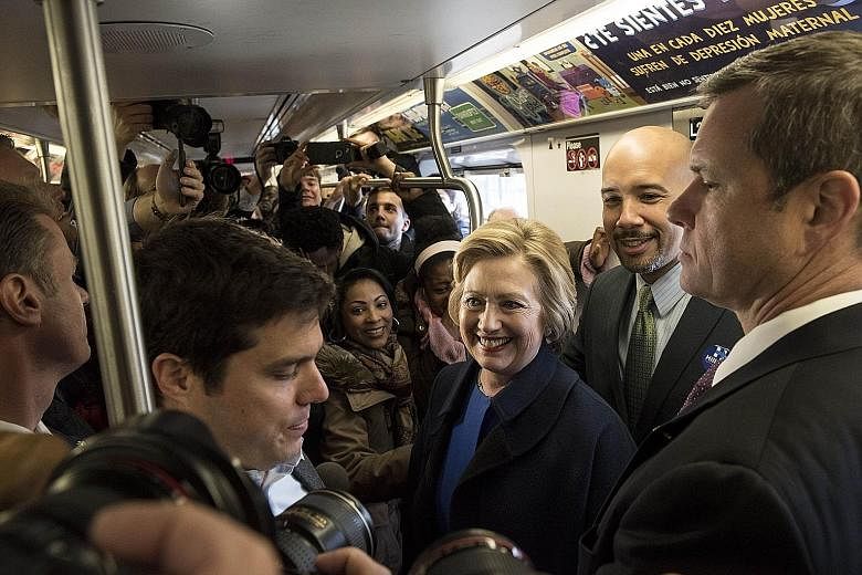 Mrs Clinton riding the No. 4 train with Bronx president Ruben Diaz Jr (behind her) during campaigning on Thursday in the borough of New York City. The latest salvos between Mrs Clinton and Mr Sanders foreshadow a more negative phase heading into the 