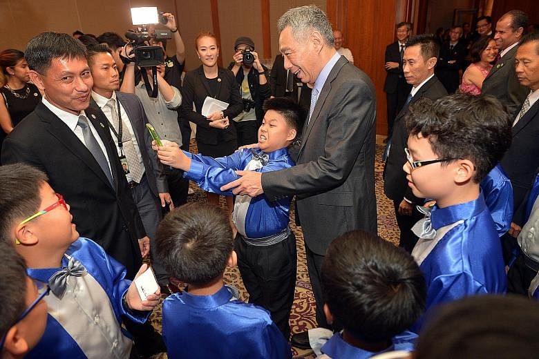 Eleven-year-old Benedict Sum, from Montfort Junior School's string ensemble, taking a wefie with PM Lee at the centennial celebrations yesterday. With them was the school's principal Wilbur Wong (far left).