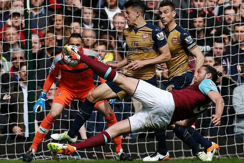 Andy Carroll acrobatically volleying into the corner for West ham's second goal. The English striker scored an eight-minute hat-trick as West Ham's last London derby at Upton Park ended in a frenetic 3-3 draw with Arsenal.