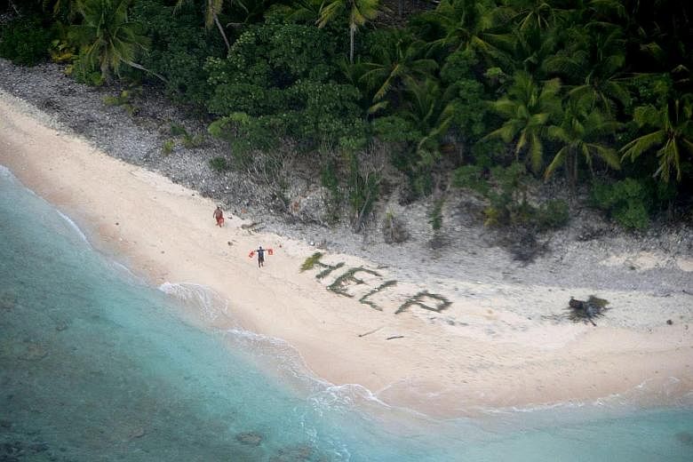 Two of three men stranded on the uninhabited island of Fanadik in Micronesia waving life jackets next to palm fronds spelling the word "HELP" as a US Navy Poseidon maritime patrol and reconnaissance aircraft discovered them on April 7. Their boat had