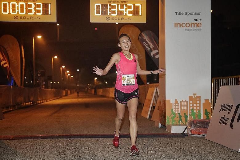 Local Olympic marathon runner Neo Jie Shi crossing the finish line in the 21.1km category of the NTUC Income Run 350 yesterday morning.