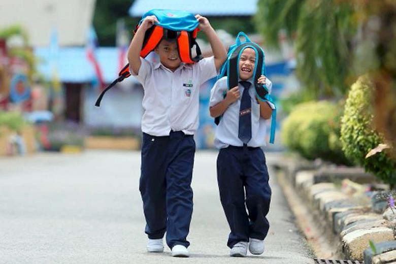 Students from a school in northern Malaysia sheltering themselves from the sun. 