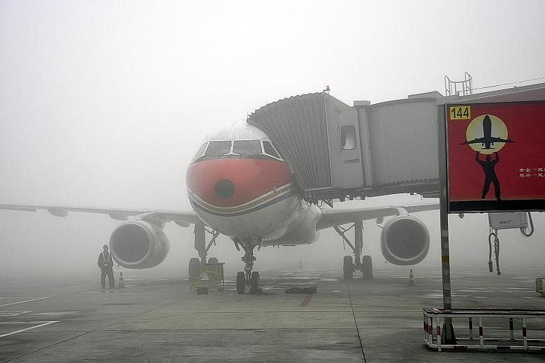 A plane in heavy fog at Shuangliu Airport in China's south-western city of Chengdu on Sunday. More than 10,000 passengers were stranded at the airport in the capital of China's Sichuan province due to the dense fog that prompted the authorities to is