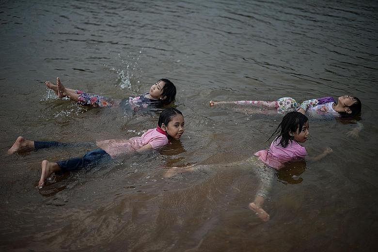 Children cooling off in a river in Temerloh, outside Kuala Lumpur, yesterday. Malaysia's Meteorological Department said the heatwave is expected to ease soon.