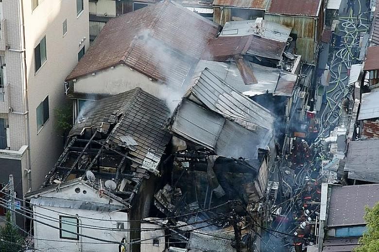 Firefighters assessing the damage from a fire yesterday in the densely packed Golden-gai district of Tokyo's Kabukicho entertainment area, known for its alleys packed with bars and eateries. The fire began around 1.20pm, according to the Tokyo Fire D