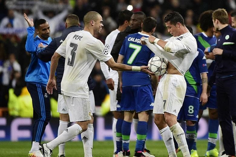 Real's star forward Cristiano Ronaldo celebrating his hat-trick with defender Pepe during their Champions League quarter-final second leg against Wolfsburg in Madrid. The 10-time European champions squeezed through 3-2 on aggregate, as the crucial aw