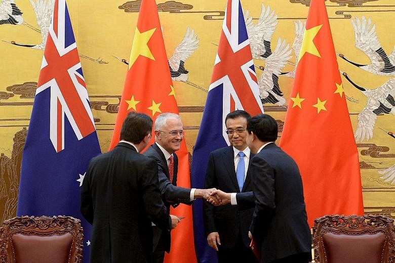 Australian Prime Minister Malcolm Turnbull and Chinese Premier Li Keqiang (both facing camera) at a signing ceremony at the Great Hall of the People in Beijing yesterday. Mr Turnbull is making his first visit to China since he became Prime Minister l