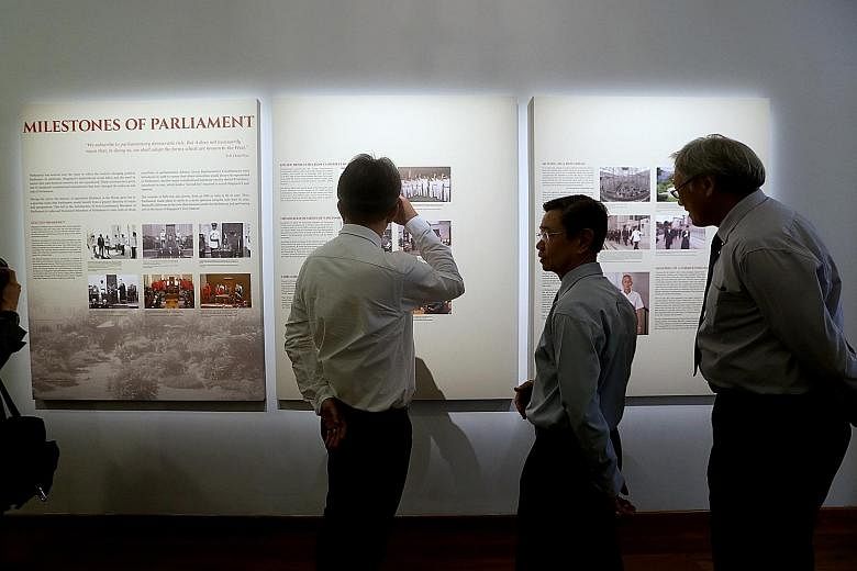 Manpower Minister Lim Swee Say, former DPM Wong Kan Seng and Defence Minister Ng Eng Hen viewing a panel at the launch of The Parliament In Singapore History exhibition at The Arts House on March 23.