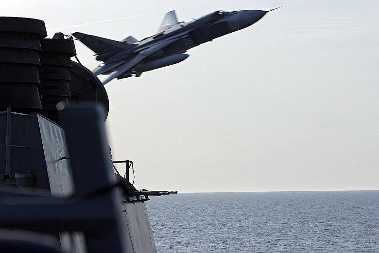 A US Navy photo shows a Russian Sukhoi Su-24 jet making a very low-altitude pass by USS Donald Cook in the Baltic Sea on Tuesday. It flew within 9m of the ship in a "simulated attack profile", the US military's European Command said. Russian military