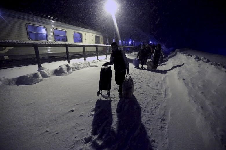 Refugees disembarking a train in Riksgransen, Sweden, and making their way on Dec 15 to a camp at a hotel touted as the world's most northerly ski resort.