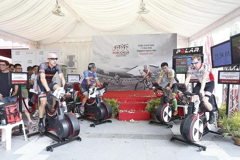 Above: Four teams of riders pedalling for 24 hours on stationary bikes with the aim of breaking the record for "Longest Distance Covered on a Stationary Bike in Six Hours". Left: ST sports editor Marc Lim (right) presenting OCBC CEO Samuel Tsien with