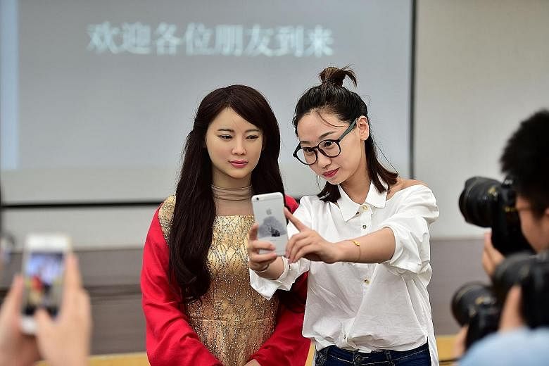 "Jiajia" an interactive robot (left), "posing" for a wefie with a journalist during its debut yesterday in Hefei, capital of east China's Anhui Province. Developed by the University of Science and Technology of China, Jiajia is able to engage in simp