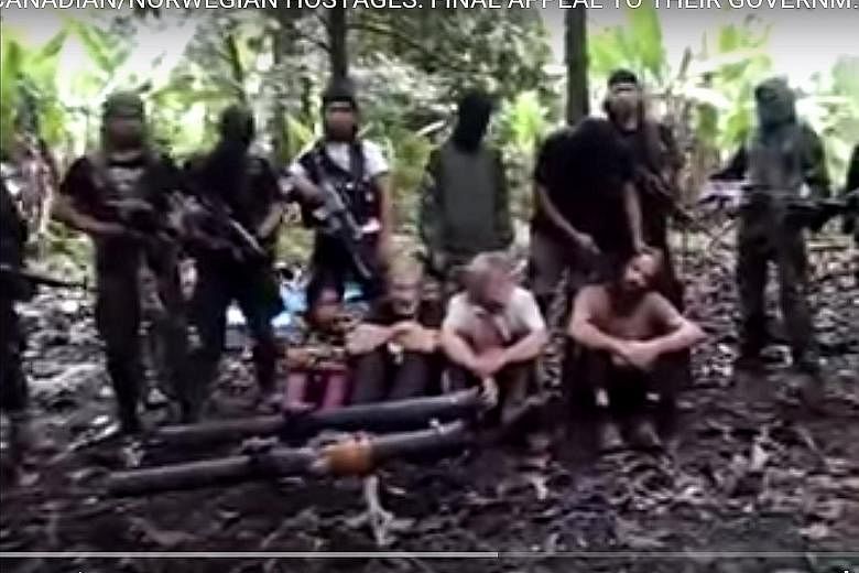 Philippine militant group Abu Sayyaf has warned in a video that it will behead one of the four foreign hostages (two Canadians, a Norwegian and a Filipino) shown if its demand for ransom is not met by the victims' governments and families by 3pm on A