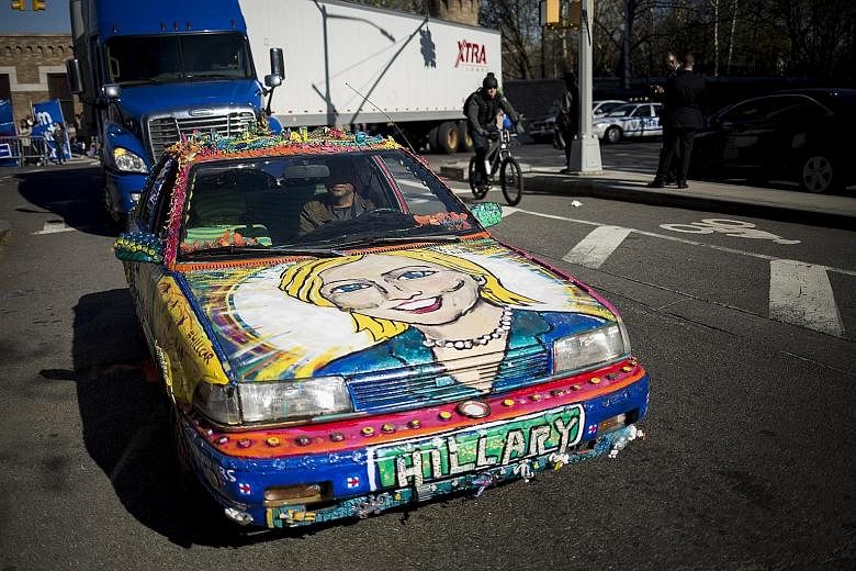 A supporter driving a car painted with Mrs Clinton's face before the start of the Democratic presidential debate in Brooklyn last Thursday.