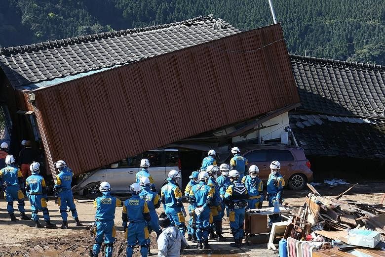 A couple crying after getting confirmation that their daughter was found dead at their house, which collapsed after an earthquake hit the town of Mashiki, in Kumamoto prefecture, yesterday. A landslide caused by an earthquake in Minamiaso village, Ku