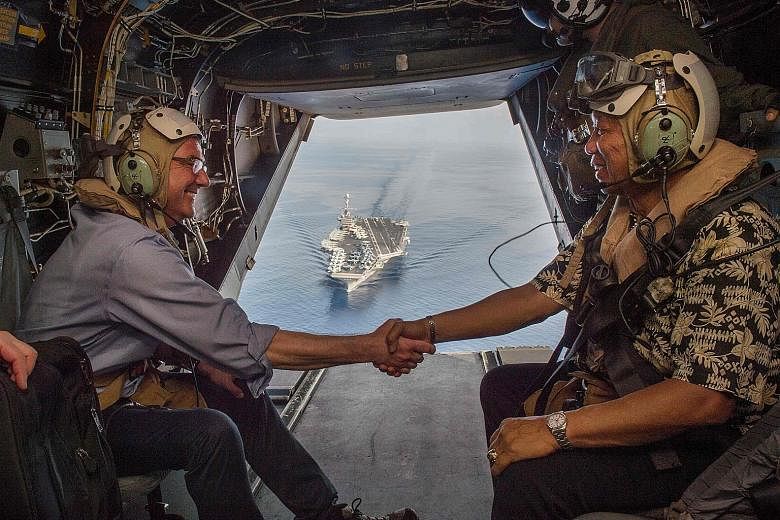 Mr Carter (left) and Philippine Secretary of National Defence Voltaire Gazmin in a Marine Corps V-22 Osprey as they depart the USS John C. Stennis last Friday.
