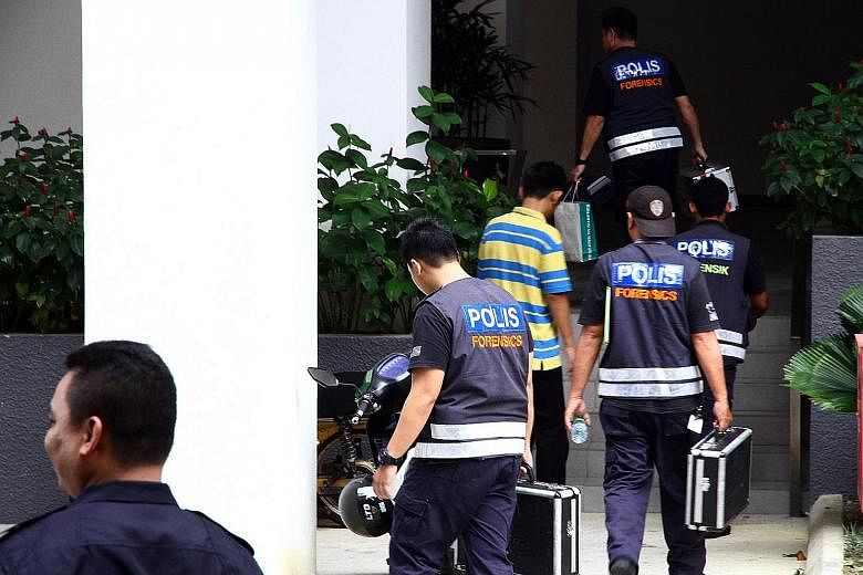 Police at the condominium block in Selangor where five homemade bombs were found yesterday following a raid.