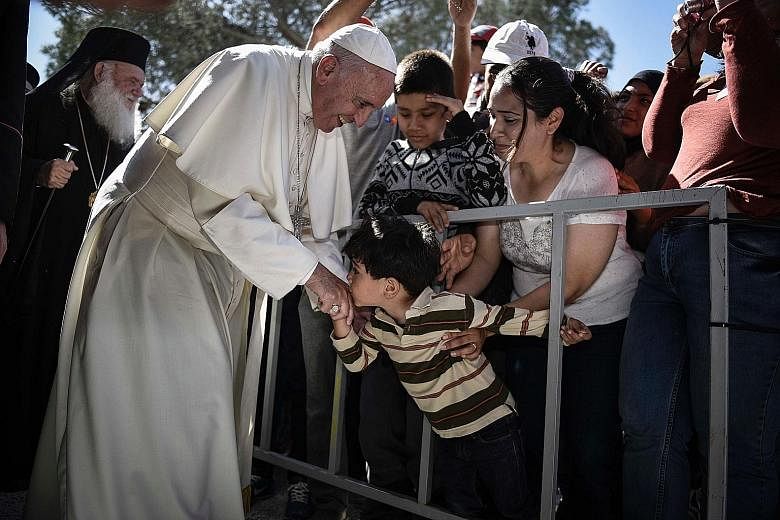 The Pope being greeted by a child during his visit to the Moria detention centre for migrants and refugees on Lesbos island in Greece on Saturday. That day, he took 12 Syrians from three families - all Muslims - home with him to the Vatican.