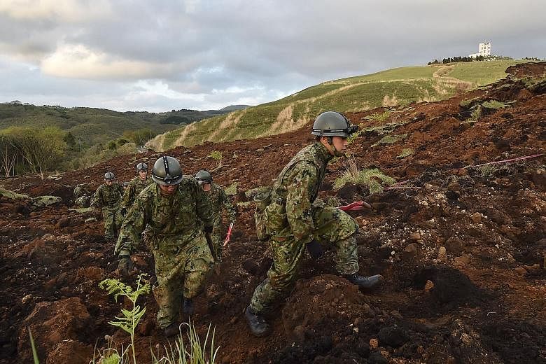 Ground Self-Defence Force troops searching for survivors at a landslide site in Minamiaso. Nine people are still missing, feared buried in collapsed houses.