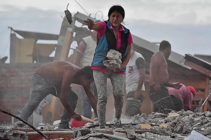 A survivor removing rubble during a search for her husband in a collapsed building in Ecuador's coastal city of Manta on Sunday.