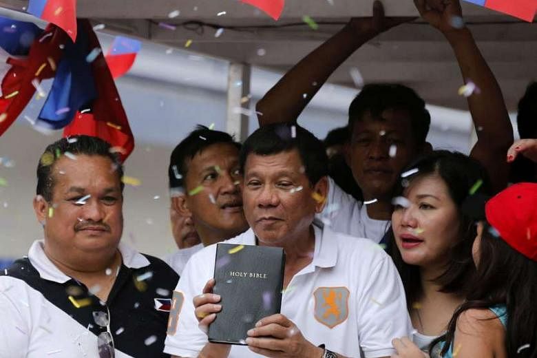 Mr Duterte holding a Bible while in a motorcade during a political rally in Marikina city, east of Manila, last week. His rape comment caused a public outcry that experts say could cost him votes. 