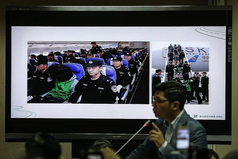 Taiwanese fraud suspects, (above, in masks) being escorted at Taoyuan Airport by Taiwanese police after being deported from Malaysia last Friday and (below, in hoods) being deported from Kenya to China as displayed on a monitor during a Taiwanese leg
