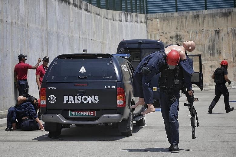 Spear's Staff Sgt Mu (with rifle) and his teammates evacuating "casualties" in Operation "Man-down" as part of the Asian Prisons Lockdown Challenge, a biennial event organised by the Singapore Prison Service for its regional counterparts. The Spear t