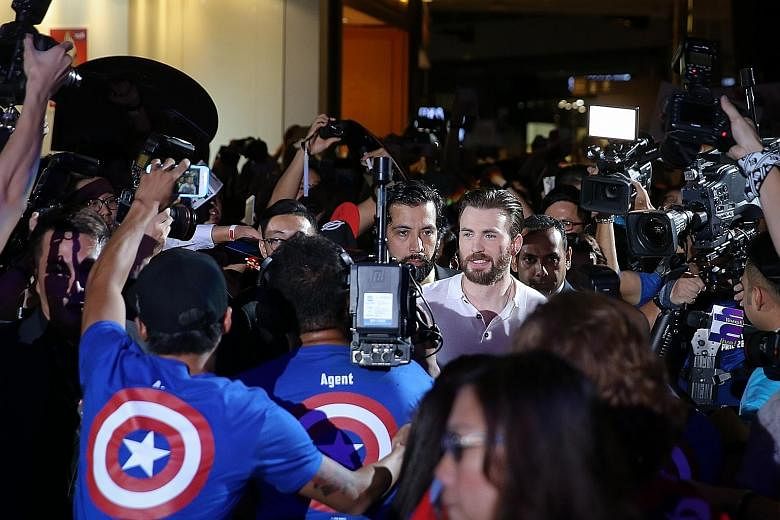 Thousands of Marvel Comics and movie fans crowded all four floors of Marina Bay Sands' shopping mall last night to catch a glimpse of Hollywood heart-throb Chris Evans (left) and his Captain America: Civil War co-stars Anthony Mackie and Sebastian St