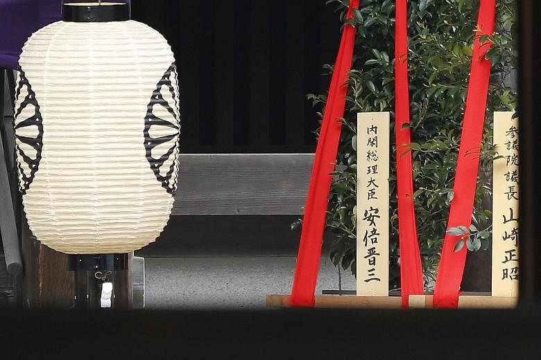 A wooden sign reading "Prime Minister Shinzo Abe" is seen on a masakaki tree - a ritual offering - from Mr Abe at the controversial Yasukuni Shrine for war dead in Tokyo yesterday. China and South Korea had suffered under Japan's occupation and colon