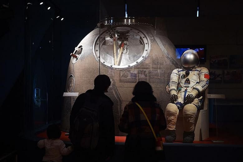The spacesuit and Shenzhou 5 re-entry capsule used by Mr Yang Liwei, China's first astronaut in space, on display at an exhibition in Beijing in March. China is trying to develop its space programme, but is still playing catch-up with the US and Russ