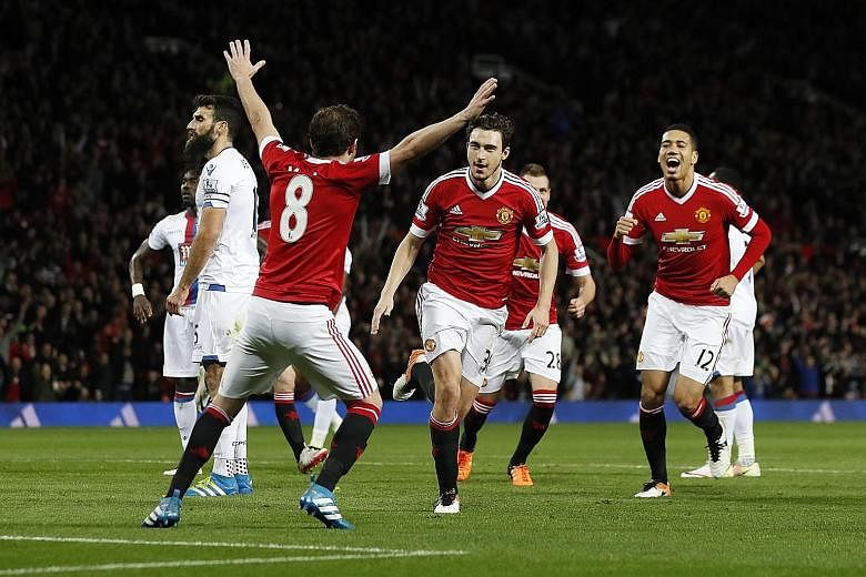 Matteo Darmian (centre) celebrates with Juan Mata (No. 8) and Chris Smalling (No. 12), after scoring United's second goal to seal a 2-0 win over Crystal Palace. Both sides will play in FA Cup semi-final ties this weekend.