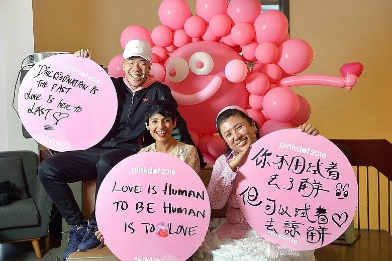 Pink Dot 2016 ambassadors (from left) rapper ShiGGa Shay, TV host Anita Kapoor and actress Liu Ling Ling with their self-written placards. Although some participants may write pro-LGBT messages that could alienate mainstream society, Pink Dot spokesm