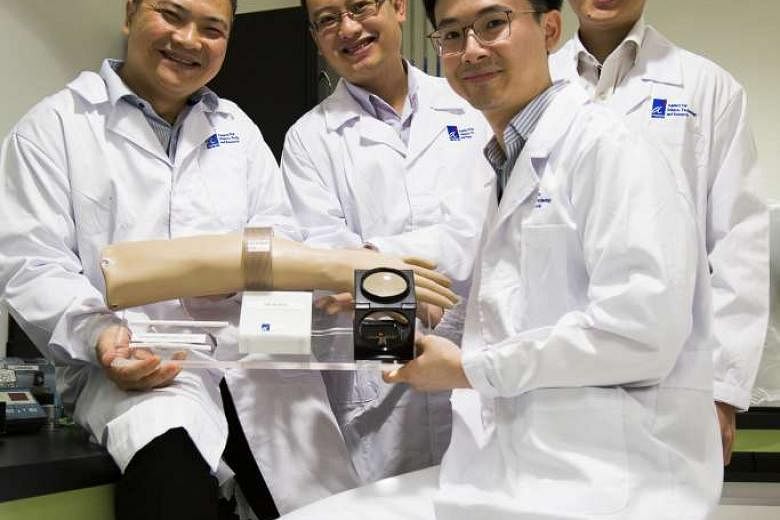 Members of the A*Star team (from left) Dr Alex Gu Yuandong, Dr Michael Ho Chee Keong, Dr Tan Ee Lim and Dr Cheong Jia Hao with the device they came up with in collaboration with vascular surgeon Benjamin Chua. 