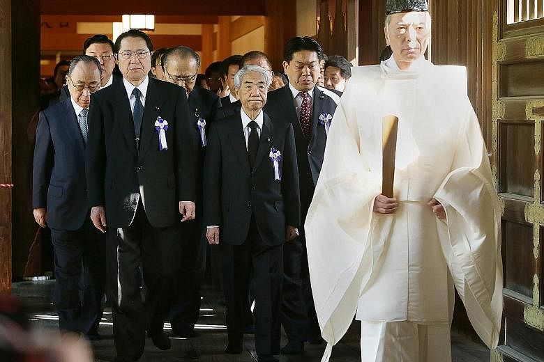 A Shinto priest leading lawmakers to the altar of Yasukuni Shrine in Tokyo yesterday.