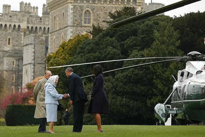 Mr Obama and First Lady Michelle Obama greeting British Queen Elizabeth II and Prince Philip after landing by helicopter at Windsor Castle for a private lunch yesterday.