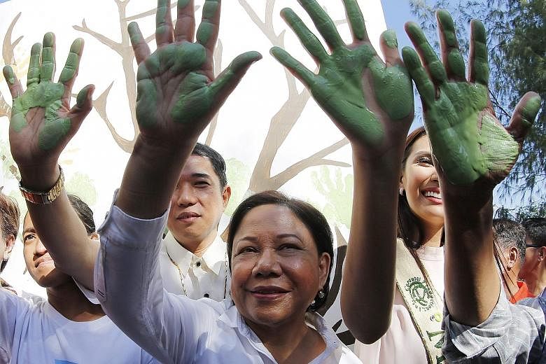 Filipino senator Cynthia Villar (centre) participating in a hand-painting exercise with environmental advocates on the coast of Freedom Island to mark Earth Day in Las Pinas City, south of Manila, yesterday. Earth Day is celebrated annually on April 